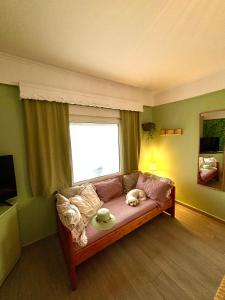 a living room with a couch and a window at T H E BERLIN Studios and Suites in Nea Vrasna