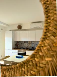 a kitchen with white cabinets and a white table at A casa del nonno Jack in Letojanni