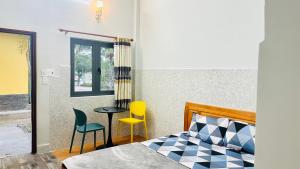 a bedroom with a bed and a table and two chairs at Bao Dien Hotel Garden in Bảo Lộc +7 photos