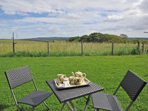 a table and chairs with a tray of tea pots at Lapwing Cottage - E5028 in Beamish