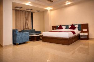 a bedroom with a bed and a couch and a chair at Hotel Jaipur Shertone in Jaipur