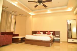a bedroom with a bed and a ceiling fan at Hotel Jaipur Shertone in Jaipur +26 photos