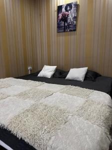 a bedroom with a bed with white sheets and a picture on the wall at Jarosta Premium Hotel in Chişinău +13 photos