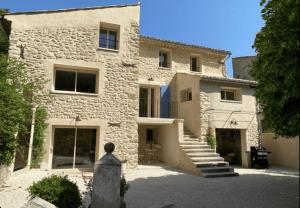 a stone house with a staircase in front of it at La Césarine in Nyons