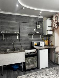 a kitchen with a sink and a stove at Jarosta Premium Hotel in Chişinău