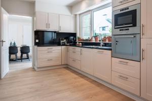a kitchen with white cabinets and a large window at roeselare stay in Roeselare
