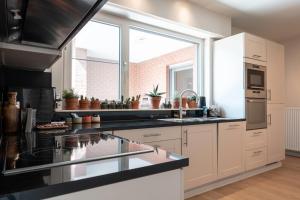a kitchen with white cabinets and a large window at roeselare stay in Roeselare