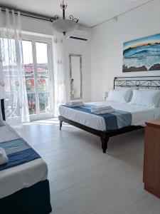 a bedroom with two beds and a large window at La vela latina in Lerici