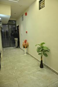 a man walking into a hallway with a plant at Hotel Shree Niwas Inn Near Airport in Jāmb