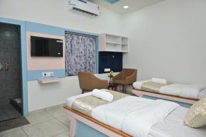 a hospital room with two beds and a flat screen tv at Hotel Shree Niwas Inn Near Airport in Jāmb