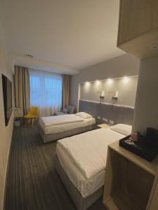 a hotel room with two beds and a television at Hotel Cztery Korony in Śrem +36 photos