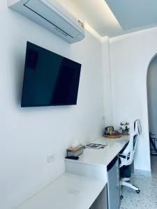 a room with a desk with a tv on the wall at on and on haus in Ban Na Nian
