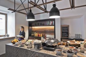 a woman standing in a kitchen with a buffet of food at Stadthotel Brunner in Schladming