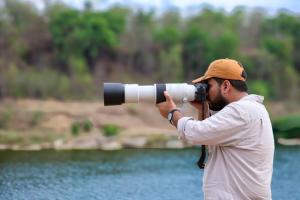 a man with a camera taking a picture of the water at Full Moon Home Stay in Jamania +15 photos