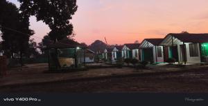 a row of houses with a sunset in the background at Full Moon Home Stay in Jamania