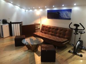 a living room with a brown couch and a table at Studio cosy au centre de Couvet in Couvet