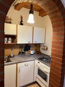 a kitchen with white cabinets and a brick wall at Papa Franks House in Ptuj