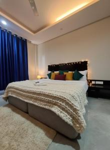 a bedroom with a large bed with colorful pillows at Hotel Giri Prime Inn Near Cyber City, Phase 3 Metro in Gurgaon