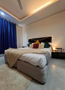 a bedroom with a large bed with blue curtains at Hotel Giri Prime Inn Near Cyber City, Phase 3 Metro in Gurgaon