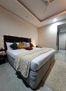 a bedroom with a large bed with colorful pillows at Hotel Giri Prime Inn Near Cyber City, Phase 3 Metro in Gurgaon