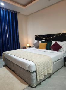 a bedroom with a large bed with colorful pillows at Hotel Giri Prime Inn Near Cyber City, Phase 3 Metro in Gurgaon