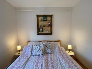 a bedroom with a bed with two lamps and a mirror at Panoráma Vendégház in Igal