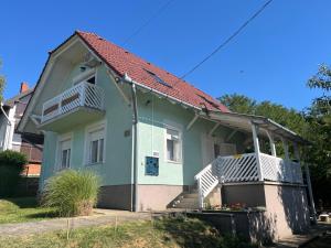 a small house with a porch and a balcony at Panoráma Vendégház in Igal
