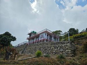 a house on top of a stone wall at Highpeak Hideway Homestay in Lava