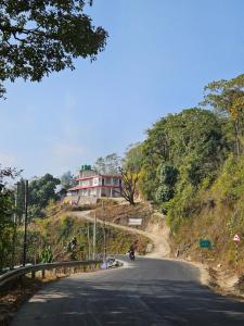 a motorcycle driving down a road on a hill at Highpeak Hideway Homestay in Lava