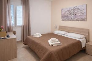 a bedroom with a bed with towels on it at Gio Rooms in Mazara del Vallo