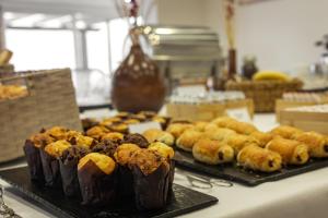 ein Tisch mit zwei Tabletts mit Gebäck und anderen Desserts in der Unterkunft Hotel Pinhal Mar in Peniche