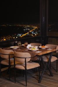 a table with chairs and plates of food and wine glasses at Kasr-ı Kikan Hotel in Mardin