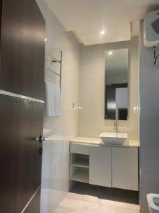 a white bathroom with a sink and a mirror at Centurion Aparthotel in Abuja +39 photos