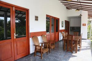 a dining room with a table and chairs at Mango Lodge in Aluthgama