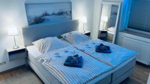 a bedroom with a bed with blue bows on it at Veermaster 1 in Breege