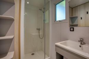 a bathroom with a shower and a sink at Camping Le Bosquet in Domme +14 photos