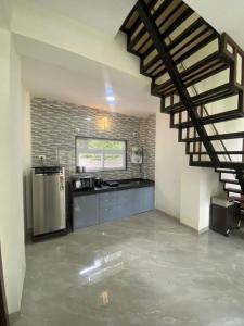 a kitchen with a staircase in a house at Nirvana Villa Karjat in Dhamni
