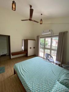 a bedroom with a bed and a ceiling fan at Nirvana Villa Karjat in Dhamni