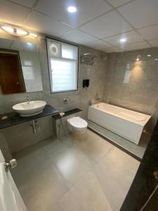 a bathroom with a tub and a toilet and a sink at Nirvana Villa Karjat in Dhamni +20 photos