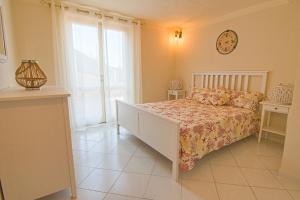 a bedroom with a bed and a clock on the wall at Villa Ginanneschi - Le Pitte in Capoliveri