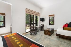 a living room with a bed and a couch and a table at Serendib Signature Resort in Digana