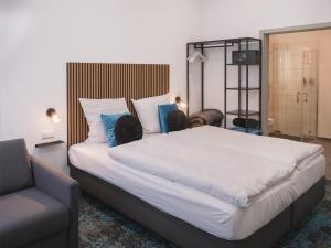ein Schlafzimmer mit einem großen Bett und einem Stuhl in der Unterkunft Das Hartmanns in Pegnitz