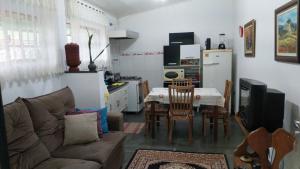 a living room with a couch and a table and a kitchen at um pedaço do paraíso in São Roque