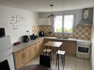 a kitchen with wooden cabinets and a table with stools at Chat-Douillet in Veuzain-sur-Loire