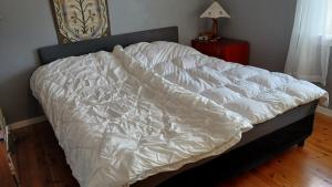 an unmade bed in a bedroom with a wooden floor at The house by the waterfall in Breim