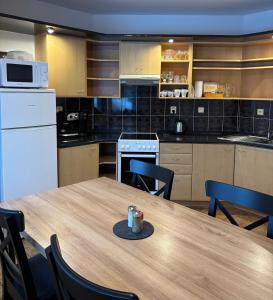 a kitchen with a wooden table with chairs and a tableasteryasteryasteryasteryastery at Apartmány Anna s welness in Trojanovice