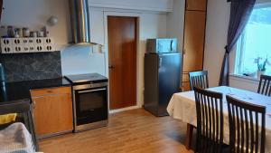 a kitchen with a refrigerator and a table and a dining room at The house by the waterfall in Breim