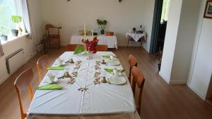 a table with a white table cloth and flowers on it at The house by the waterfall in Breim