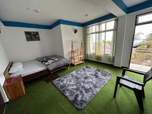a bedroom with a bed and a chair and a window at Highpeak Hideway Homestay in Lava