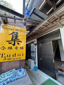 a guest house sign on the side of a building at tsudoi in Tanabe